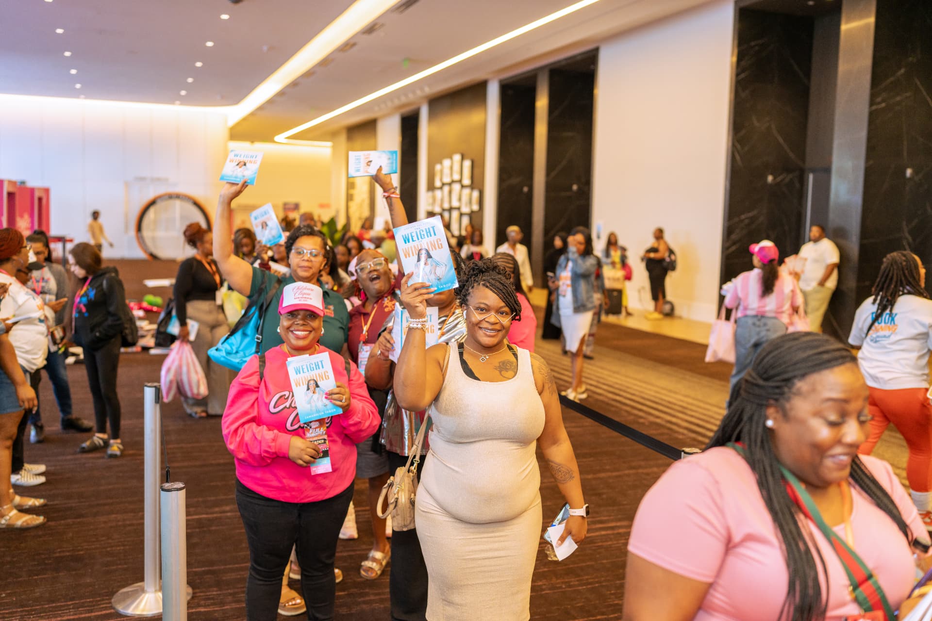 Launch day attendees raising copies of The Weight of Winning by Jamarrion Tabor